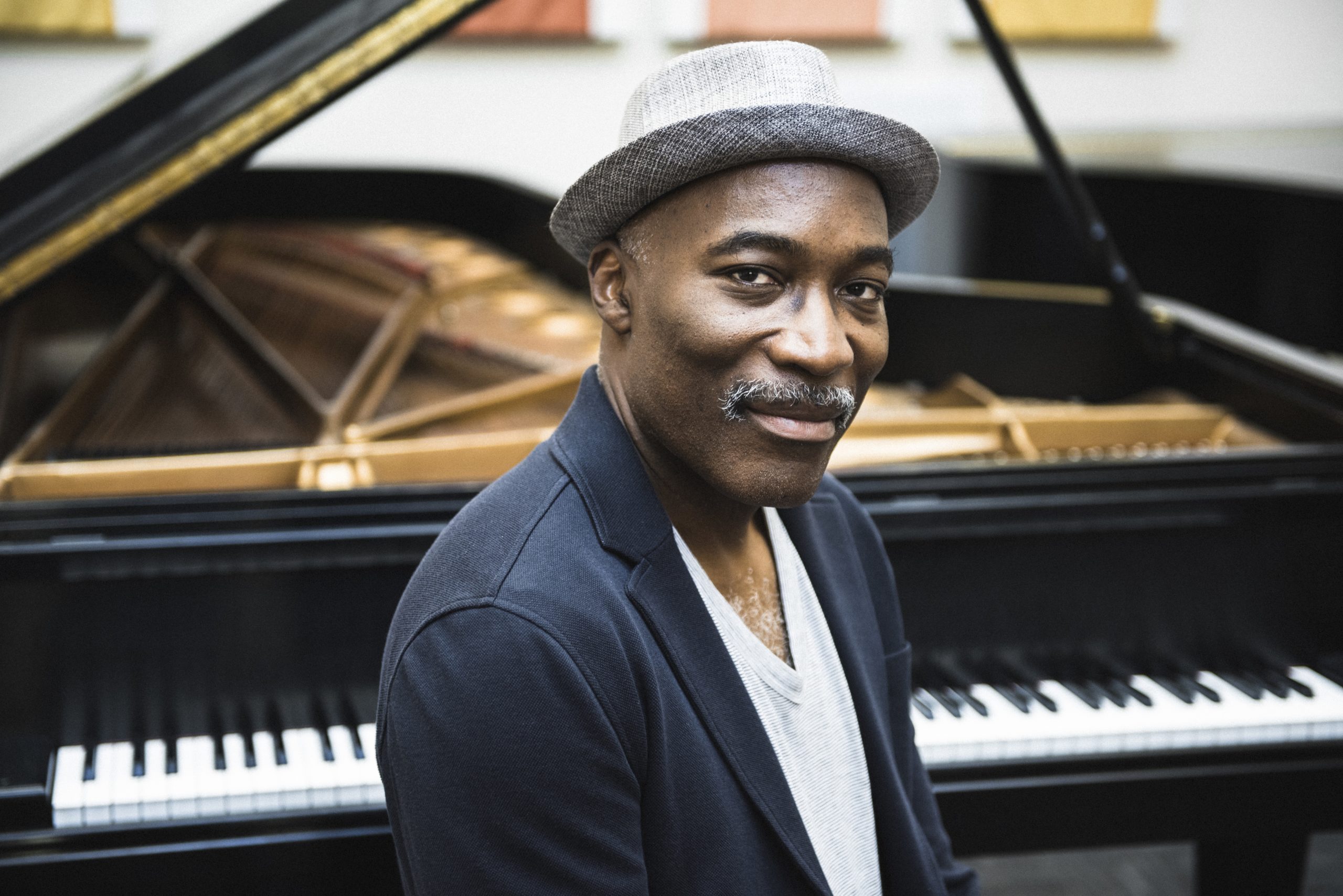 Darrel Grant sitting in front of a grand piano