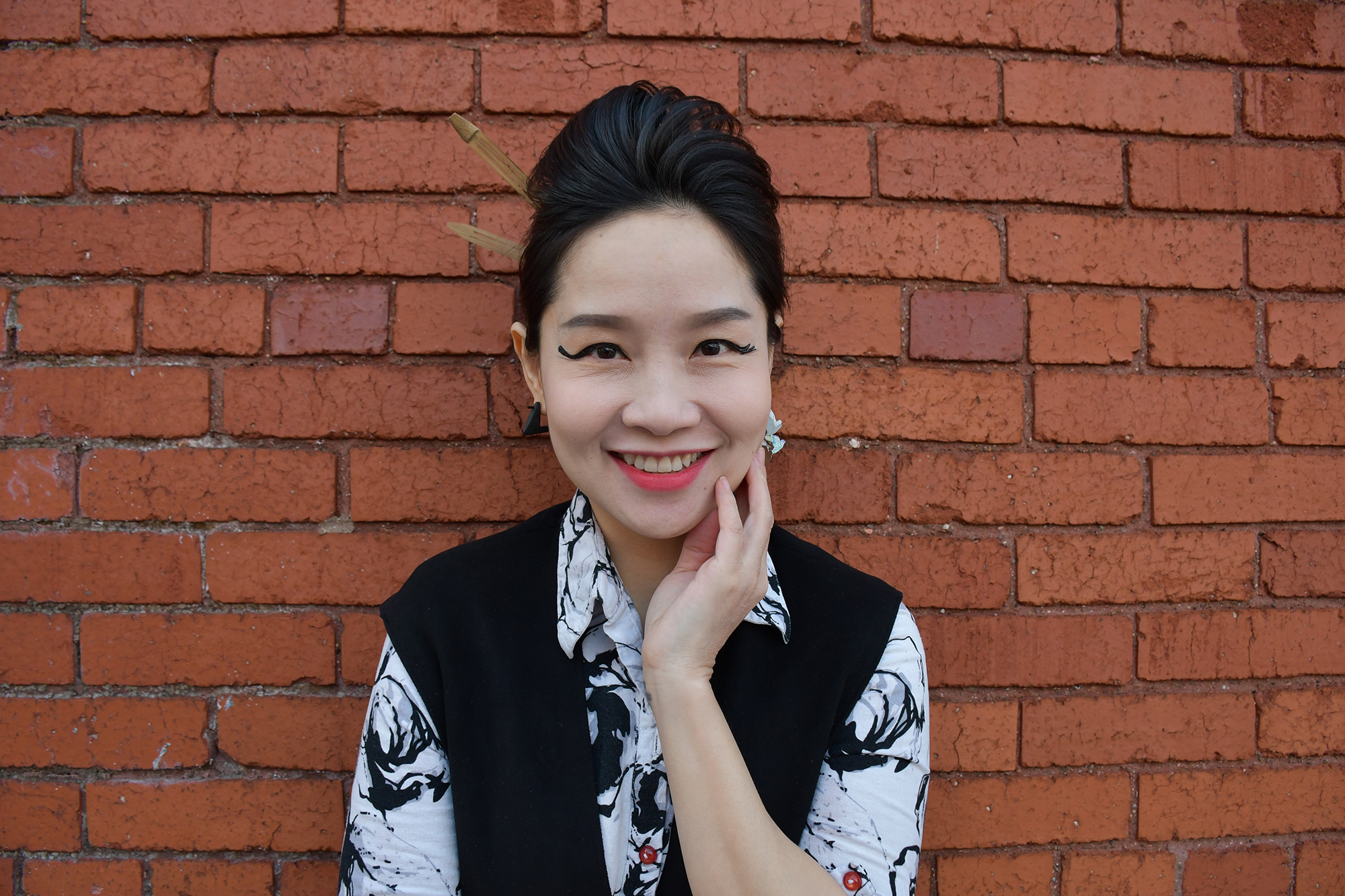 Mai Khoi standing against a brick wall.