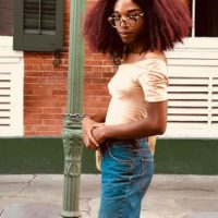 A woman posing outside with red hair