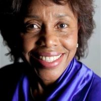 A Cuban woman posing wearing an indigo, silk top