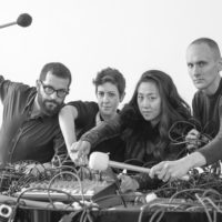 A black and white shot of the ensemble with wires and mallets