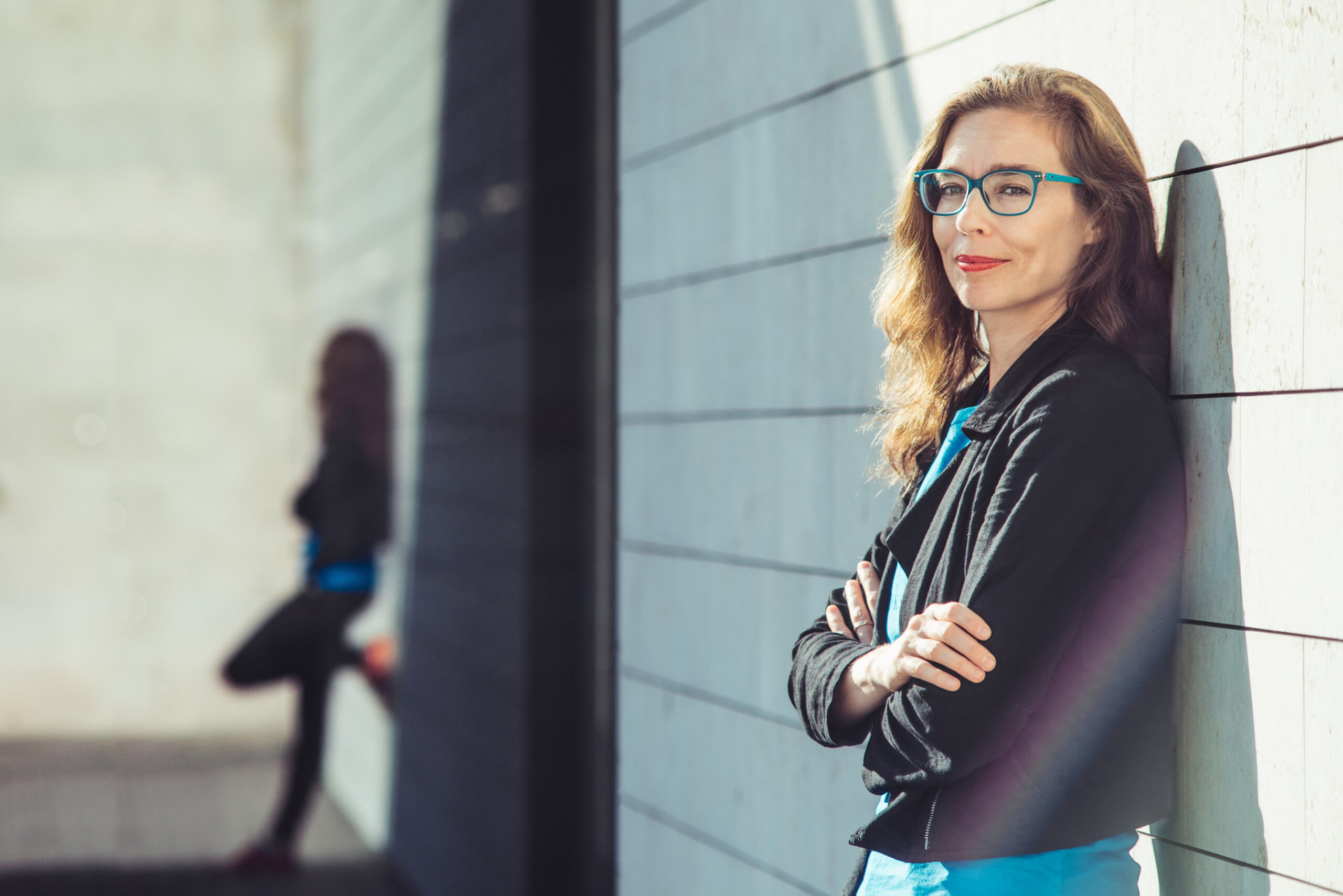 Žibuoklė Martinaitytė standing against a wall and her shadow. (Photo by Tomas Terekas)