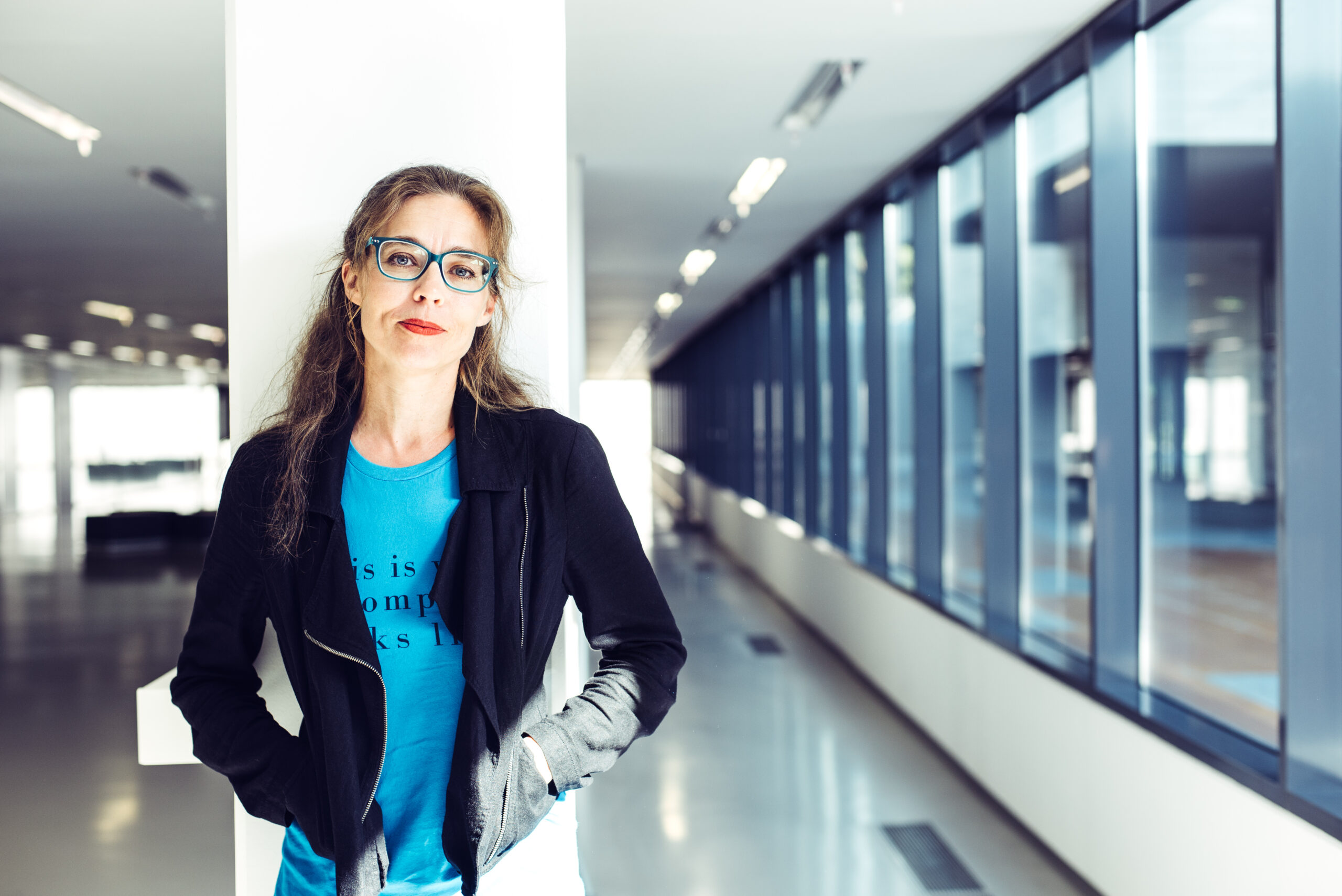 Žibuoklė Martinaitytė standing against a pillar in a corridor. (Photo by Tomas Terekas)
